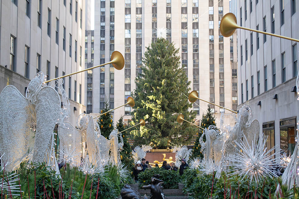 A huge Christmas tree outside Rockefeller Center in New York, surrounded by angel ornaments